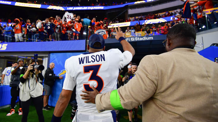 Russell Wilson waves to the crowd as he leaves the field
